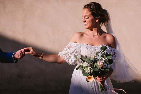 Portrait photo d'une mariée qui tient la main du marié dans le Luberon