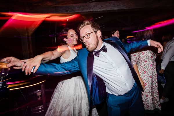 Mariés dansant sur la piste avec des effets de lumière filée.