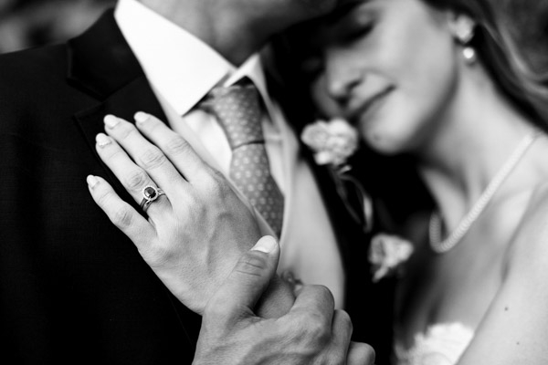 Gros plan sur la bague de fiançailles et l'alliance de la mariée.