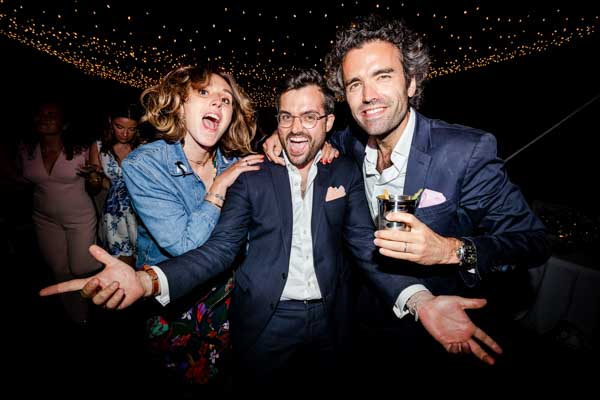 Trois invités de mariage riant et posant joyeusement lors de la soirée dansante.