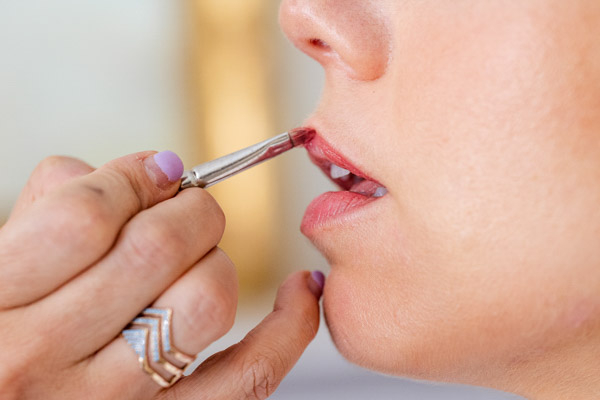 Maquillage des lèvres de la mariée avec un pinceau en Provence.