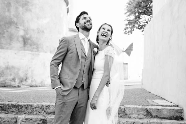 Portrait de mariage en noir et blanc d'un couple qui rit aux éclats.