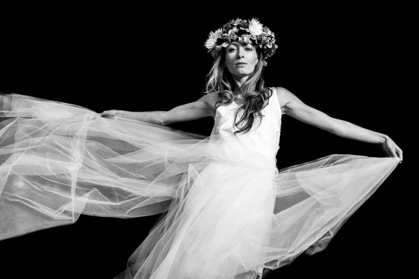 Portrait artistique en noir et blanc d'une mariée faisant voler son voile en Provence.