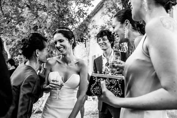 Mariée et ses invitées éclatant de rire lors d'un cocktail en extérieur en Provence.
