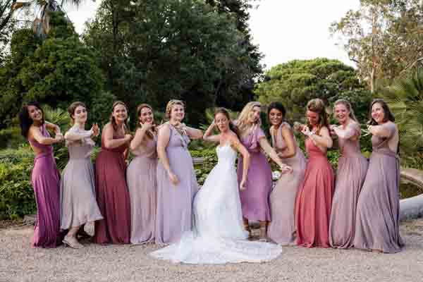 La mariée entourée de ses demoiselles d'honneur en robes pastels.