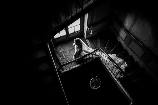 Vue de haut d'une mariée descendant un escalier en pierre d'un mas.