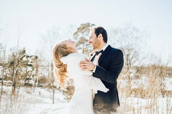 Portrait d'un couple de mariés s'embrassant dans un paysage enneigé des Alpes avec une lumière vive et douce.