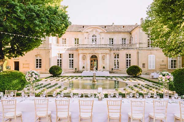 Façade majestueuse du Château Martinay à Carpentras avec sa fontaine et sa table de réception dressée dans les jardins.