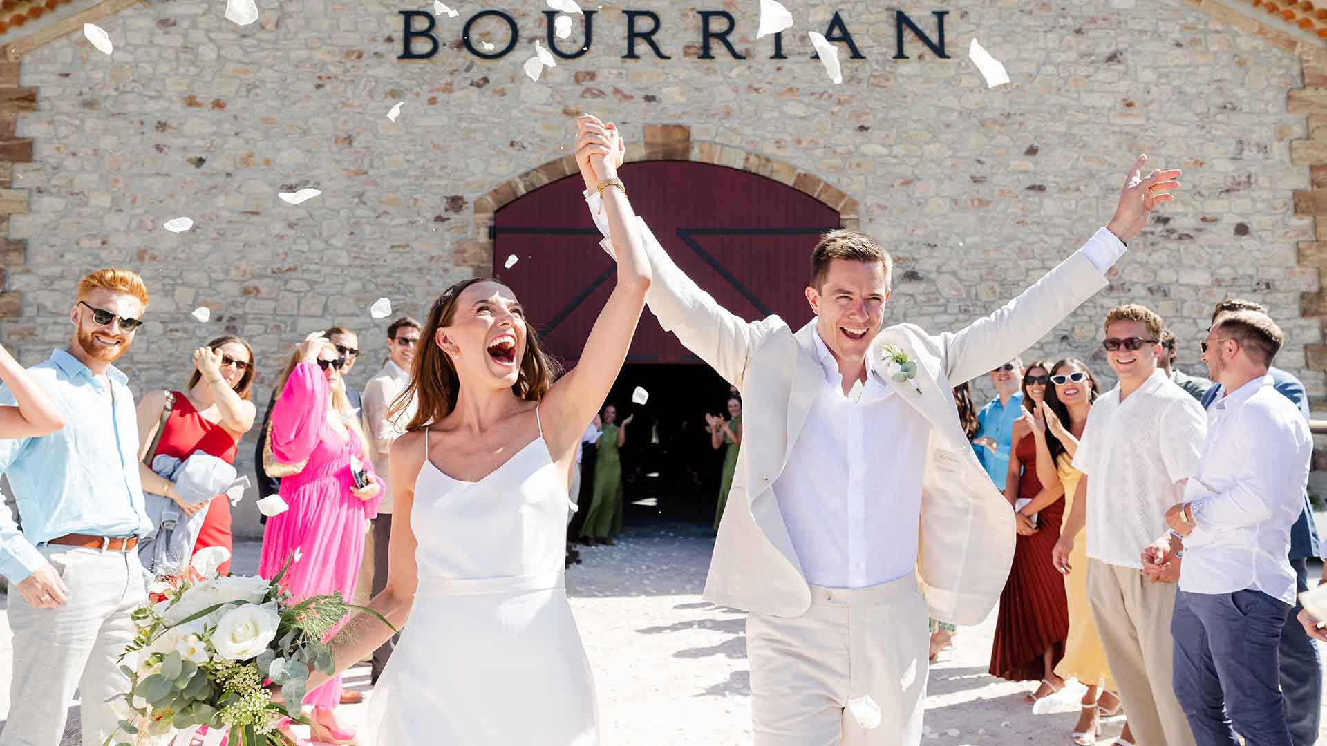 photographe-mariage-domaine-du-bourrian-gassin Sortie de cérémonie des mariés sous un lancer de pétales blancs au Domaine du Bourrian à Gassin.