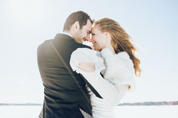 Portrait intimiste d'un couple de mariés en hiver, lumière douce et chaleureuse.