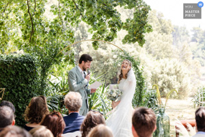 Photographie de mariage primée montrant une mariée éclatant de rire pendant le discours de son époux lors d'une cérémonie laïque en Provence.