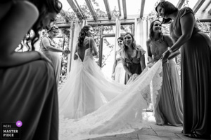 Photographie de mariage primée en noir et blanc montrant une mariée souriante entourée de ses demoiselles d'honneur lors des préparatifs dans un salon lumineux en Provence.