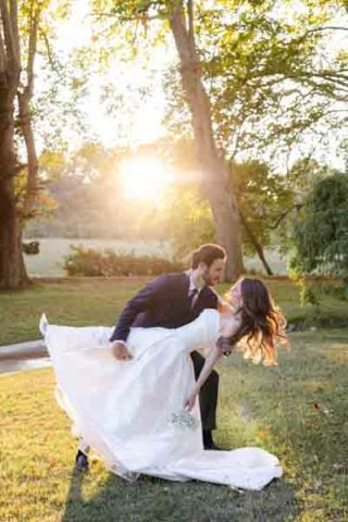Mariés se promenant dans un champ de fleurs en Provence, avec un fond d'arbres et une lumière douce.
