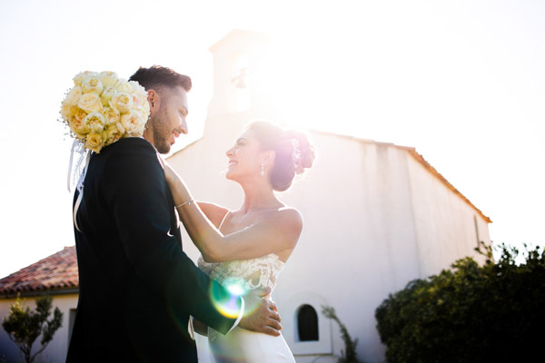 Mariés devant une chapelle provençale sous le soleil.