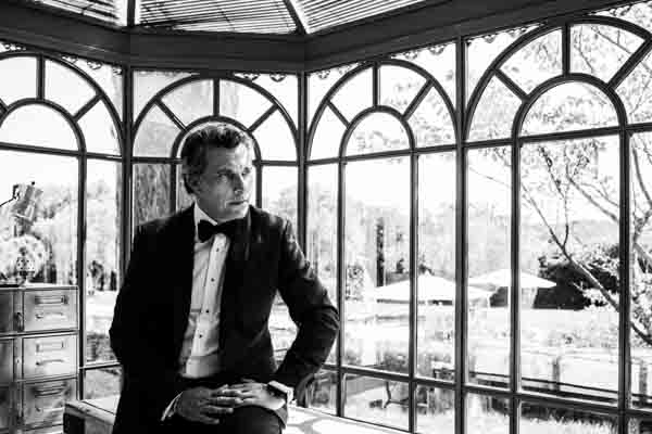 Portrait en noir et blanc d'un marié en smoking chic.