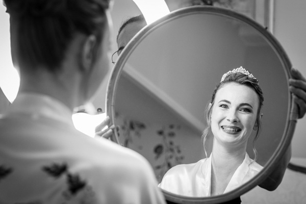 Portrait de la mariée se regardant dans un miroir pendant les préparatifs.