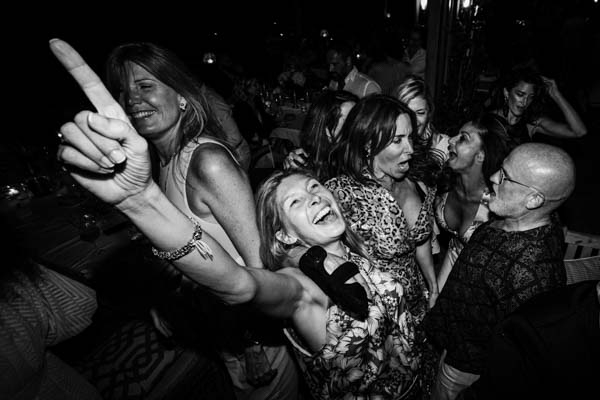 Groupe d'invitées dansant en noir et blanc au mariage.