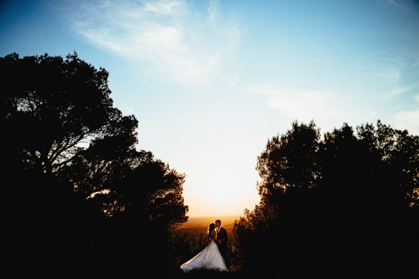 Silhouette d'un couple de mariés s'embrassant au coucher du soleil en Provence.