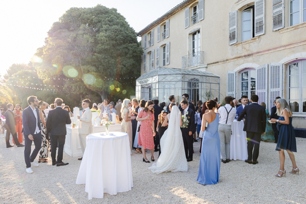 Cocktail de mariage en extérieur devant la verrière de la Villa Brignac sous le soleil de Provence.