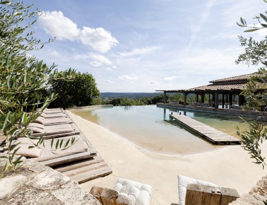 Espace détente avec piscine naturelle de style lagon et transats au Domaine de Brès, lieu de mariage à Goudargues.