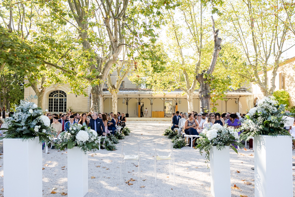 Réception de mariage sur la terrasse du château offrant une vue dégagée sur le parc arboré.