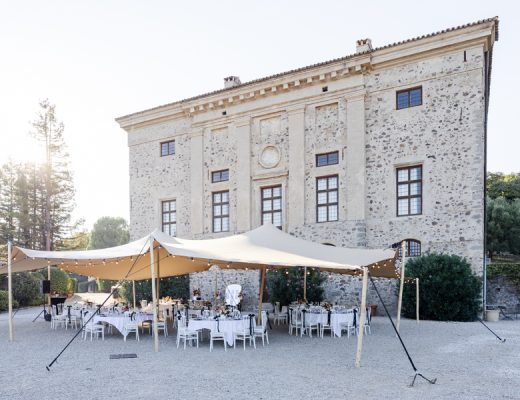 Installation de la réception de mariage avec une tente stretch sur l'esplanade en gravier devant le magnifique Château de Vaugrenier.