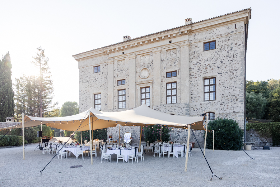Installation de la réception de mariage avec une tente stretch sur l'esplanade en gravier devant le magnifique Château de Vaugrenier.